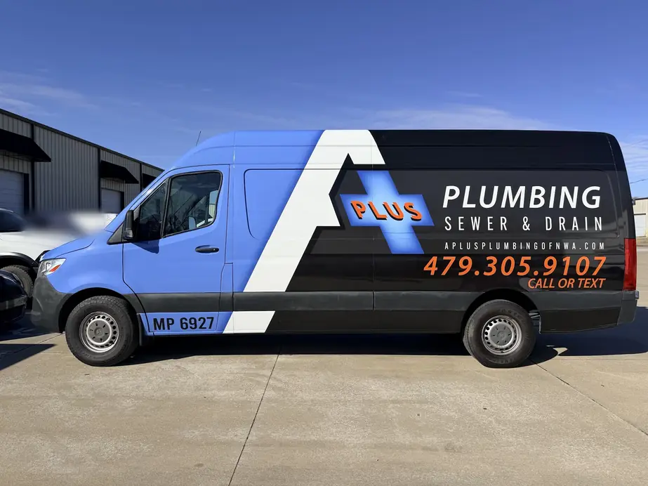 The A Plus Plumbing Sprinter van, blue with a black and white stripe, lettered Plumbing, Sewer & Drain with Call or text on the wrap